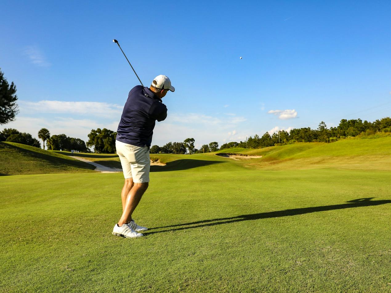 Golfeur au départ sur un fairway ensoleillé