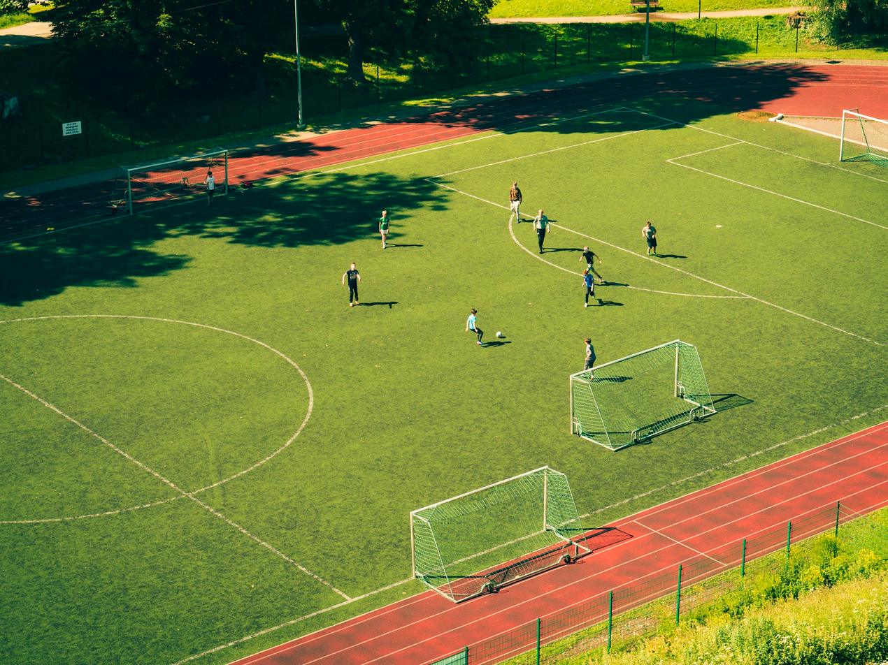 Terrain de football municipal vu du ciel, entouré d’une piste d’athlétisme